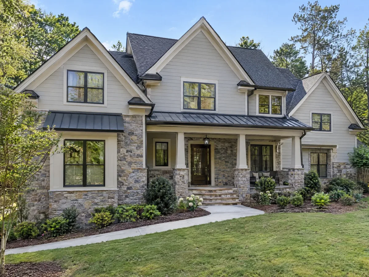 Finished two-storey stone and siding custom home with landscaped front yard