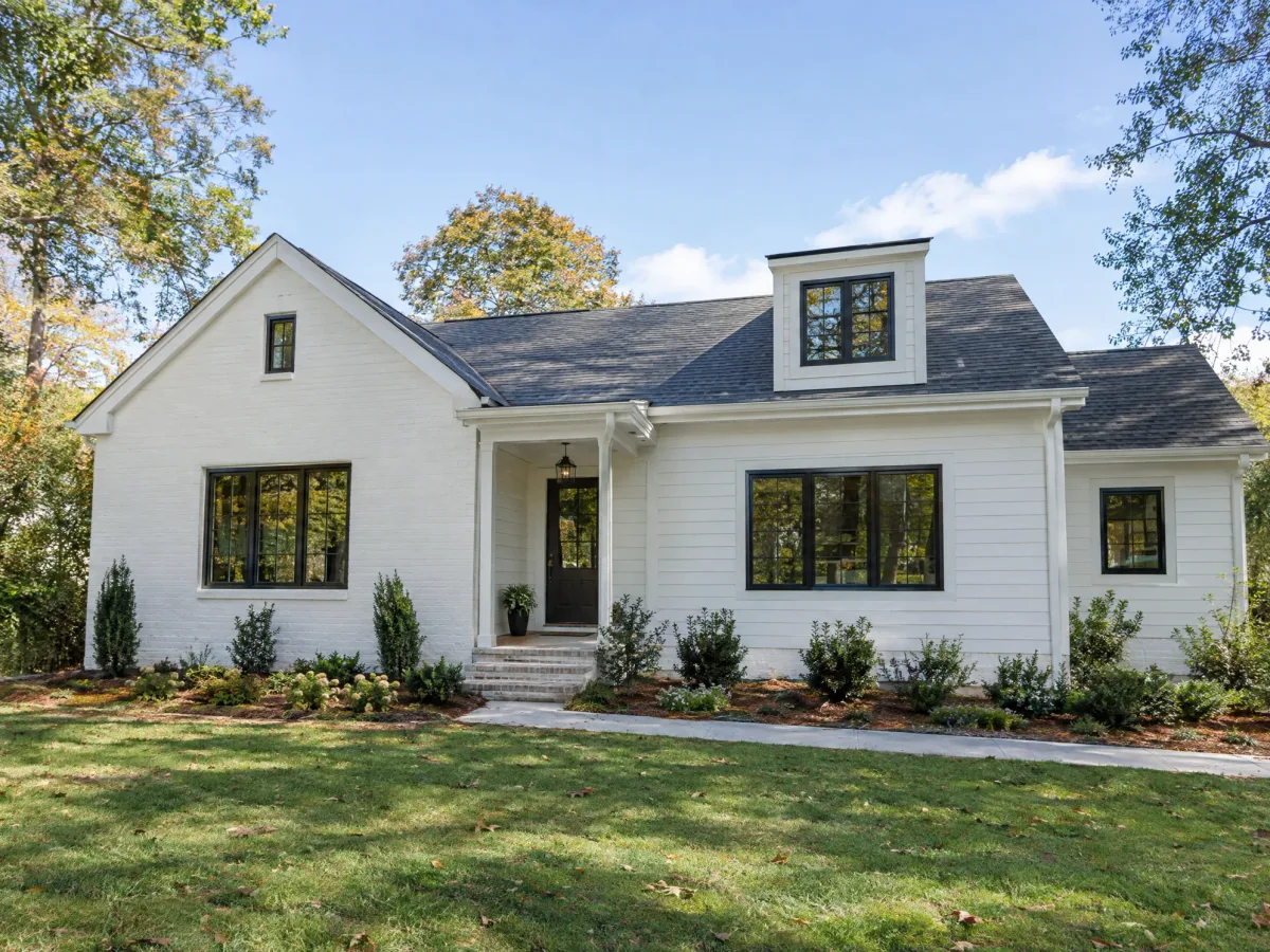 Finished white brick and siding house with dormer and new walkway
